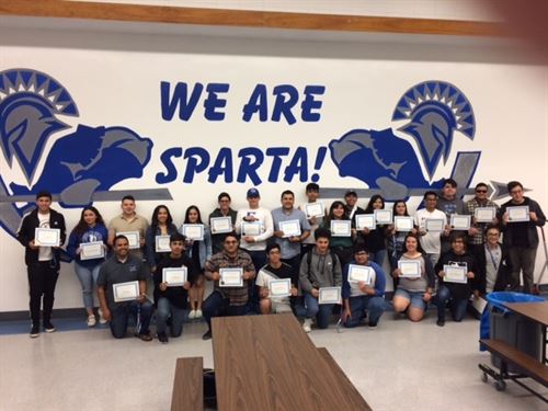 group of students holding awards in cafeteria